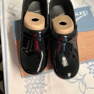 Dansko black patent leather clogs.